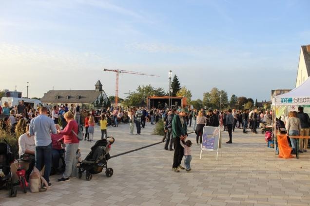 Blick auf den Katharina-von-Künßberg-Platz mit Menschen im Sommer.