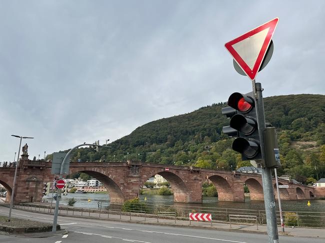 Verkehrssignalanlage mit Verkehrszeichen und im Hintergrund die Alte Brücke