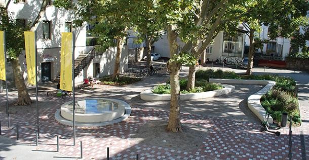 Der umgestaltete Theaterplatz mit einem Brunnen und viel Grün.