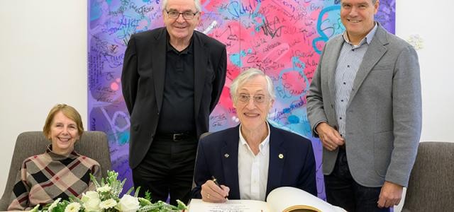 Physik-Nobelpreisträger John C. Mather trug sich im Beisein von (von links) Ehefrau Cheryl Hoffmann, Jakob Köllhofer, Programmchef des Deutsch-Amerikanischen Instituts (DAI), und Oberbürgermeister Eckart Würzner im Rathaus in das Goldene Buch der Stadt Heidelberg ein. 