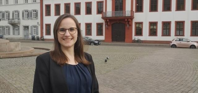 Porträtfoto von Ann-Kathrin Riedel vor dem Heidelberger Schloss.