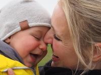 Eine Mutter hält ihr Baby auf dem Arm, beide lachen (Foto: Andreas Burgdorf)