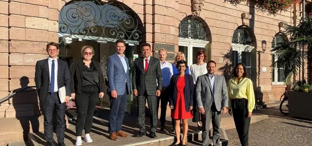 Eine Gruppe von Menschen steht auf der Treppe, die ins Heidelberger Rathaus führt.