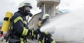 Zwei Feuer-wehr-männer in schwarz-gelber Ausrüstung halten zwei Schläuche aus denen Wasser spritzt. (Foto: Rothe)