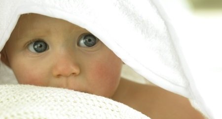 Ein Kleinkind mit Handtuch bedeckt. 