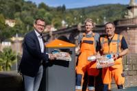 Bürgermeister Raoul Schmidt-Lamontain (links) demonstriert mit Theresa Janz und Ditmar Heid von der städtischen Abfallwirtschaft die Vorteile der Großmülleimer, in deren Schlund auch Pizzakartons passen.