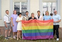 Menschen zeigen eine bunte Flagge