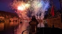 Das Behelfslöschboot beobachtet das Feuerwerk und die Boote auf dem Neckar Ein Feuerwehrmann blickt vom Behelfslöschboot auf den Neckar, das Feuerwehr und die liegenden Boote.