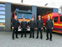 Feuerwehrkommandant Heiko Holler (l). mit dem wiedergewählten Führungsteam der Freiwilligen Feuerwehr Wieblingen: Frank Karlein (2. v.r.), Harald Schwarz und Torsten Bender (3 und 4. v.r.). (Foto: Stadt Heidelberg) Fünf uniformierte Feuerwehrmänner stehen vor einer geöffneten Garage mit zwei Feuerwehreinsatzwägen.