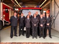 Kontinuität in Kirchheim: Das wiedergewählte Führungsteam mit Michael Fanous (l) und seinen Stellvertretern Andreas Klinger (2.v.l.) und Frank Schrödersecker (4 v.l., hintere Reihe). (Foto: Feuerwehr Heidelberg) Neun Feuerwehrleute stehen in einer offenen Garage vor einem Feuerwehreinsatzwagen.