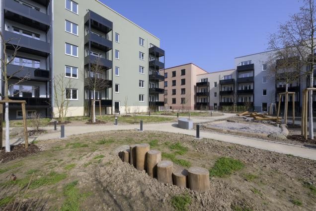 Die neuen Häuser der GGH auf dem Hospital-Areal haben jeweils eine individuelle Fassade und liegen an begrünten Innenhöfen, die Treffpunkte für die neuen Bewohnerinnen und Bewohner bilden. (Foto: Philipp Rothe) Innenhof eines Gebäudekomplexes.
