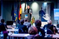 Oberbürgermeister Prof. Dr. Würzner hinter einem Rednerpult bei der Eröffnungsfeier der 1. Heidelberger Symposium Migration zum russischen Angriffskrieg in der Ukraine.