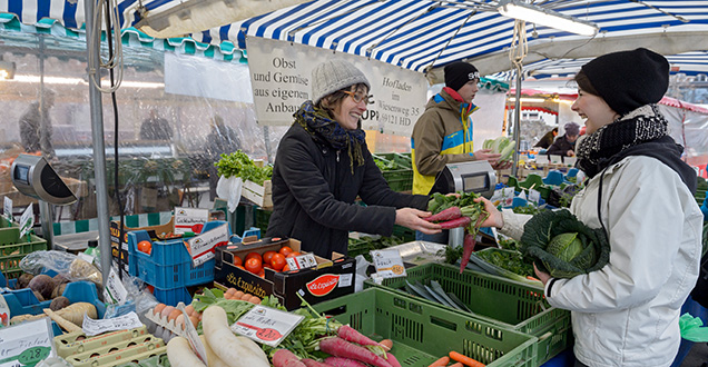 Market day in Handschuhsheim (Photo: Rothe) Woman at a market stall hands over the vegetables to her customer. (Photo credits: Rothe)