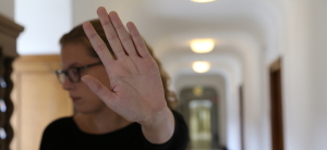Junge Frau hebt abwehrend die Hand (Foto: Stadt Heidelberg) Junge Frau hebt abwehrend die Hand