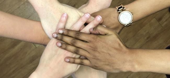 Hände mit verschiedenen Hautfarben übereinander