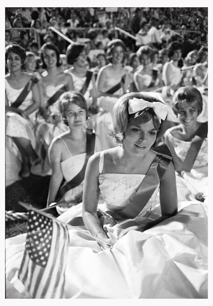 Republican election party, Southern United States, USA, 1964 The black-and-white photo shows a group of women seated in white princess dresses with sashes at a Republican election party.