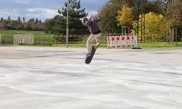 Person auf Skateboard in der Luft.