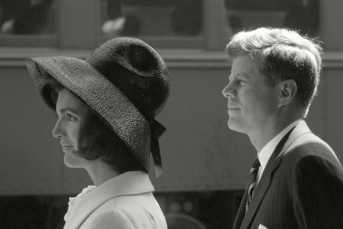 The black-and-white photo shows Jackie and John F. Kennedy in left profile, awaiting Hassan II of Morocco.