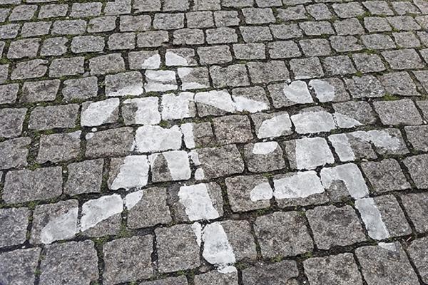 Piktogramme in der Sandgasse zeigen die Grundrisse von zwei rennenden Kindern, die mit weißer Farbe nachgebessert wurden (Foto: Stadt Heidelberg)