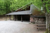 Eine Holz-Hütte im Wald mit einem Platz vor der Hütte und Bänken und Tischen zum Sitzen (Foto: Stadt Heidelberg)