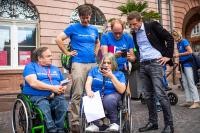 Fünf Menschen, von denen zwei einen Rollstuhl benutzen, schauen auf ihre Handys (Foto: Tobias Dittmer)