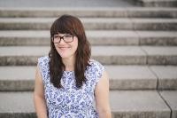 Carolin Callies, eine junge Frau, sitzt auf einer Treppe. Sie eine Heidelberger Autorin. (Foto: Thiemer)