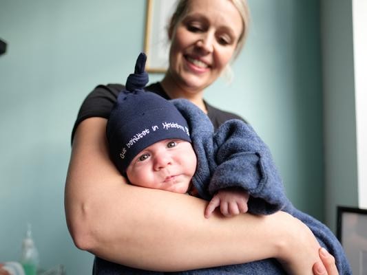 Kleinkind auf dem Arm einer Frau (Foto: Bohla) Kleinkind auf dem Arm einer Frau