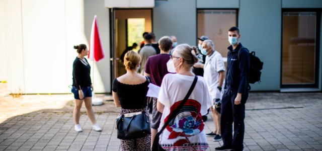 Menschen stehen in einer Schlange vor dem Seniorenzentrum