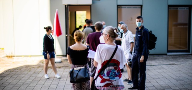 Menschen stehen in einer Schlange vor dem Seniorenzentrum 