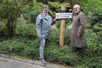 Auf dem Heidelberger Bergfriedhof enthüllen Bürgermeister Wolfgang Erichson und Wolfgang Becker, Leiter des Friedhofsamtes, ein Schild des Immateriellen UNESCO-Kulturerbes.