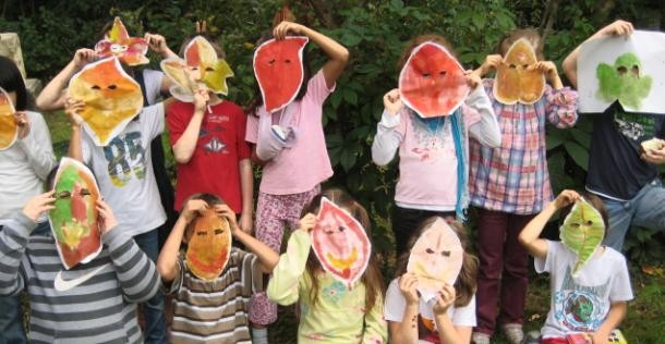 Kindergruppe mit Blättermasken.