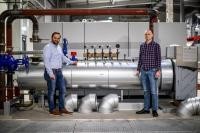 Tobias Enders und Marco Unger im Technikgebäude des ENERGIEparks Pfaffengrund vor der Power-to-Heat-Anlage, einem Bauteil der iKWK-Anlagen. (Foto: Stadtwerke Heidelberg) Zwei Männer vor der Power-to-Heat-Anlage.