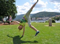 Nichts wie raus: Jede Menge Outdoor-Angebote bietet der Heidelberger Ferienpass für Kinder ab sechs Jahren. (Foto: Christopher Jelen) Ein Kind schlägt ein Rad auf einer Wiese.