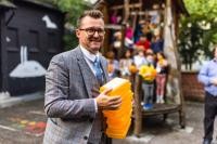 Abfallvermeidung von Anfang an: Die Kinder der Klasse 1a der Friedrich-Ebert-Grundschule (im Hintergrund) haben am 28. September 2021 von Heidelbergs Klimabürgermeister Raoul Schmidt-Lamontain persönlich je eine Mehrweg-Frühstücksbox geschenkt bekommen. (Foto: Dittmer) Umweltbürgermeister Raoul Schmidt-Lamontain teil Frühstücksboxen aus.