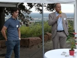 Oberbürgermeister Prof. Dr. Eckart Würzner (r.) und Winzer Andreas Bauer begrüßen die Gäste. (Foto: Stadt Heidelberg) Links steht Winzer Andreas Bauer, rechts Oberbürgermeister Prof. Dr. Eckart Würzner mit einem Mikrofon vor dem Mund.