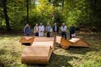 V.l.n.r.: Sabine Lachenicht, Leiterin des Umweltamtes, Stephan Hörl, Kaufmännischer Leiter der Rehaklinik Heidelberg-Königstuhl, Chefarzt Dr. Robert Nechwatal, Oberbürgermeister Prof. Dr. Eckart Würzner, Dirk Teegelbekkers, Geschäftsführer von PEFC Deutschland e.V., Alwin Wallenwein, Gesamtbetriebsratsvorsitzender der Rehaklinik und Tillmann Friederich, stellvertretender Amtsleiter des Landschafts- und Forstamtes im PEFC-zertifizierten „Kur- und Heilwald“ mit drei vom Forstamt eigens gezimmerten Liegebänken. (Foto: Dittmer) Oberbürgermeister Würzner mit allen Beteiligten hinter Holzliegen auf einer Lichtung.