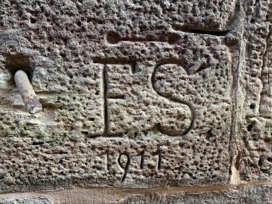 Die Initialen "ES" mit der deutlich zu erkennenden Jahreszahl 1911 in den Stein gehauen.