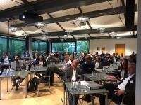 Die Zuhörerinnen und Zuhörer waren interessiert an den Plänen für das Interkommunale Gewerbegebiet Heidelberg-Leimen. (Foto: Stadt Leimen) Blick in einen Raum mit Tischen, an denen Menschen sitzen und nach vorne schauen.