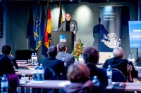 Heidelbergs Oberbürgermeister Prof. Dr. Eckart Würzner eröffnete das 1. Heidelberger Symposium Migration zum russischen Angriffskrieg in der Ukraine mit einem Grußwort. (Foto: Susanne Lencina) Oberbürgermeister Prof. Dr. Würzner hinter einem Rednerpult bei der Eröffnungsfeier der 1. Heidelberger Symposium Migration zum russischen Angriffskrieg in der Ukraine.