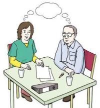 Eine Frau und ein Mann sitzen am Tisch und sprechen miteinander. Auf dem Tisch liegen Papier und ein Ordner sowie zwei Gläser.