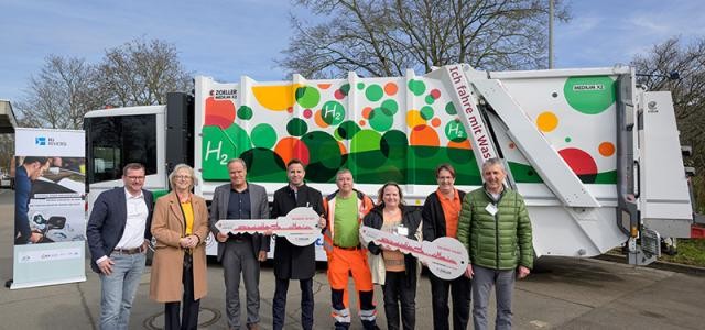 Gruppenfoto vor dem neuen Wasserstoff-Müllfahrzeug.