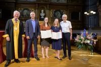 Prof. Dr. Bernhard Eitel, Rektor der Universität Heidelberg, Markus Lautenschläger, die beiden Preisträgerinnen Dr. Victoria Ingham und Prof. Dr. Christine Selhuber-Unkel sowie Manfred Lautenschläger. (Foto: Universität Heidelberg - Kommunikation und Marketing/Rothe) Drei Männer und zwei Frauen stehen auf einer Bühne, die beiden Frauen haben jeweils eine aufgeschlagene Mappe in der Hand.