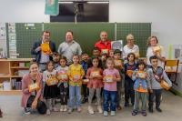 Bürgermeister Raoul Schmidt-Lamontain überreichte in diesem Jahr den Kindern der Klasse 1a in der Grundschule Emmertsgrund die beliebten Frühstücksboxen mit den regionalen Tomaten. (Foto: Tobias Dittmer) Eine Grundschulklasse mit Frühstücksboxen