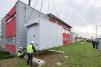 An der Westseite des Feuerwehrhauses Kirchheim wurde der Container mit dem großen Notstromaggregat mit dem Kran auf ein Fundament gehoben. Über vorab gelegte Leitungen ist das Aggregat direkt mit dem Feuerwehrhaus verbunden und geht im Notfall eines Stromausfalls automatisch in Betrieb. (Foto: Rothe) Notstromaggregat wird eingesetzt.
