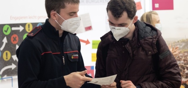 Ein Feuerwehrmann im Gespräch mit einem Studenten