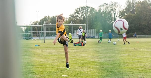 Ein Junge kickt einen Fußball.