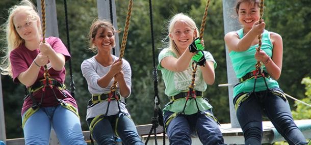 Vier lachende Jugendliche im Hochseilgarten