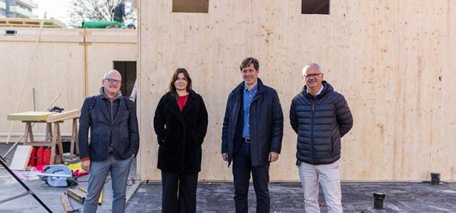 Architekt Weber, Hochbauamtsmitarbeiterin Moruno, Bürgermeister Odszuck und Hochbauamtsleiter Heußer stehen vor einem Holzmodul.