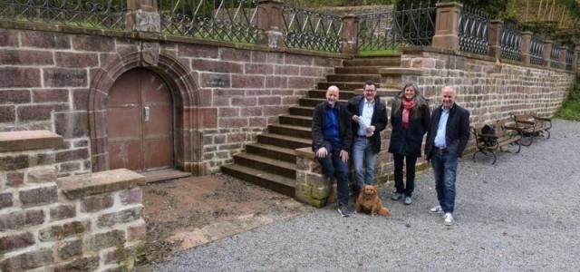 Dr. Ernst Baader, Leiter des Landschafts- und Forstamtes, Klimabürgermeister Raoul Schmidt-Lamontain, Umweltamtsleiterin Sabine Lachenicht und Rainer Nobis, Vorsitzender des Vereins „Freunde und Förderer des Wolfsbrunnen e. V.“ vor der Stützmauer.