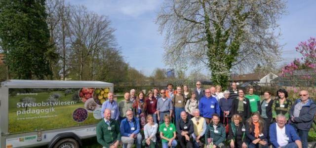 Teilnehmerinnen und Teilnehmervor einem Baum und neben einem LKW-Anhänger mit Aufschrift bei der Programmeröffnung von „Natürlich Heidelberg 2024“